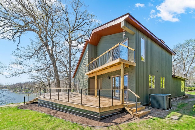 rear view of house featuring central air condition unit and a deck with water view