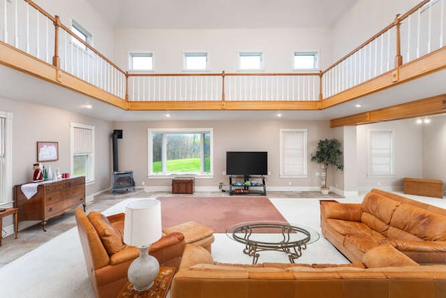 living room with a wood stove and a towering ceiling