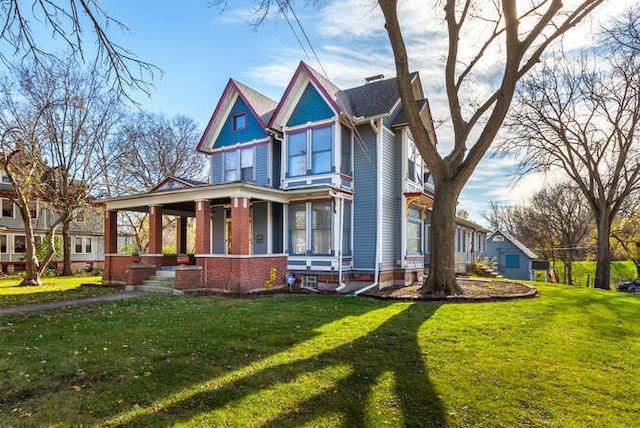 victorian home featuring covered porch and a front lawn