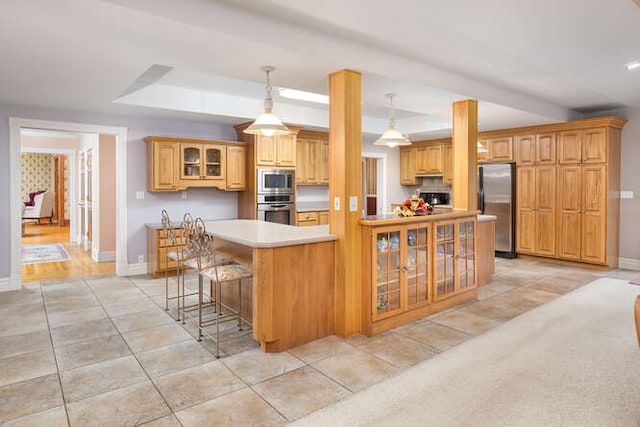 kitchen with a center island, stainless steel appliances, decorative light fixtures, a kitchen bar, and light tile patterned flooring