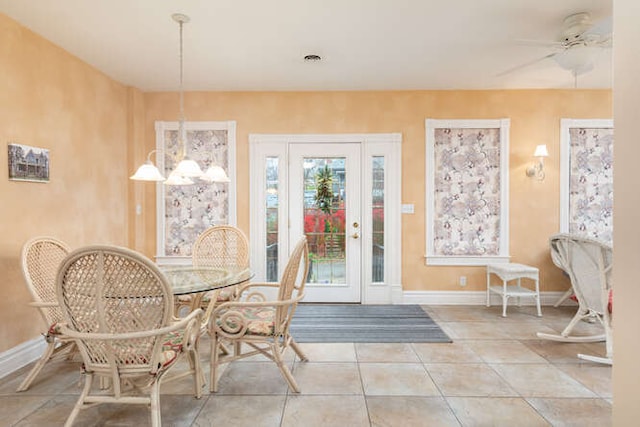 dining room featuring ceiling fan with notable chandelier and light tile patterned flooring