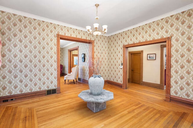 interior space featuring wood-type flooring, an inviting chandelier, and crown molding