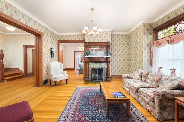 living room with wood-type flooring, an inviting chandelier, and crown molding