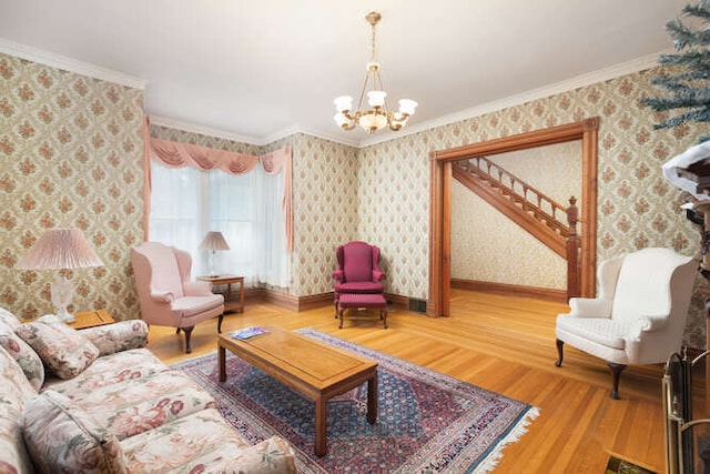 sitting room with hardwood / wood-style flooring, an inviting chandelier, and crown molding