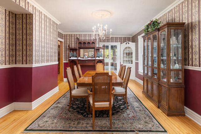 dining area featuring a notable chandelier, crown molding, and light hardwood / wood-style flooring