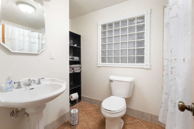 bathroom with tile patterned flooring, a shower with curtain, and toilet