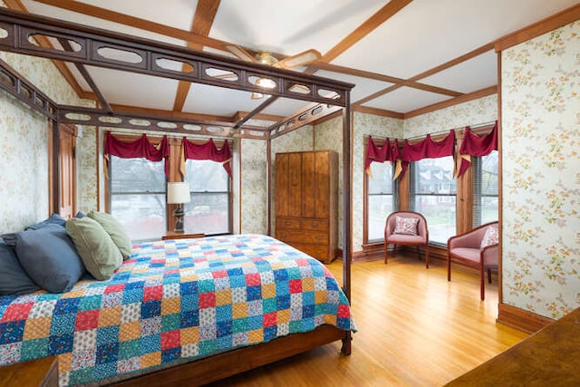 bedroom featuring hardwood / wood-style flooring and beamed ceiling