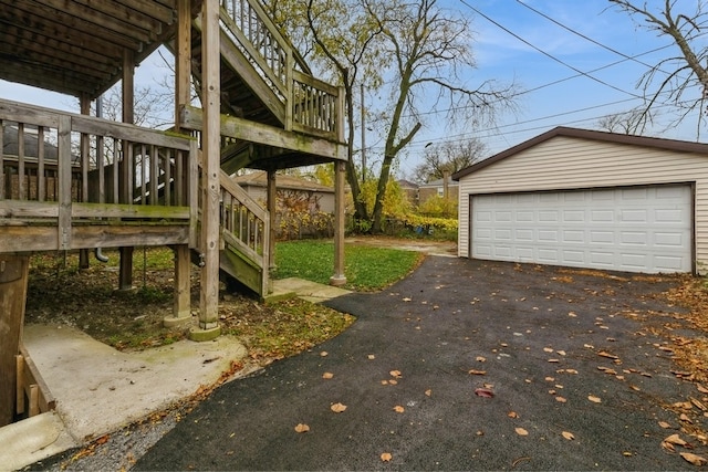 view of yard with a garage, an outbuilding, and a wooden deck