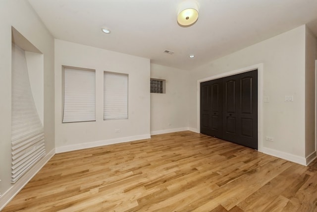 unfurnished bedroom with a closet and light wood-type flooring