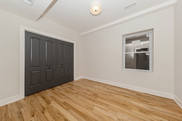 unfurnished bedroom featuring light hardwood / wood-style floors and a closet