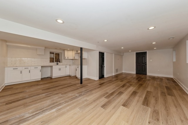 unfurnished living room featuring light hardwood / wood-style floors and sink