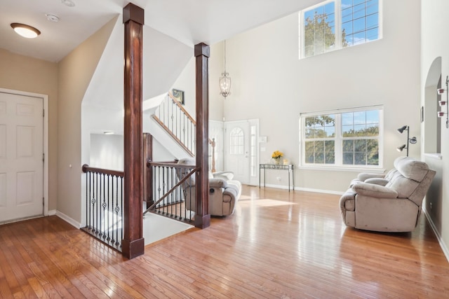 entryway featuring wood-type flooring and a towering ceiling