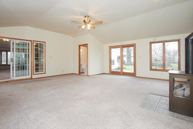 unfurnished living room with ceiling fan, light colored carpet, and vaulted ceiling