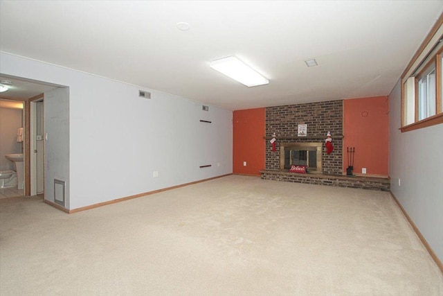 unfurnished living room featuring carpet flooring and a brick fireplace