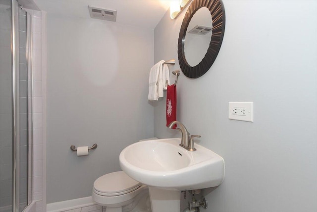 bathroom with sink, tile patterned flooring, a shower with shower door, and toilet