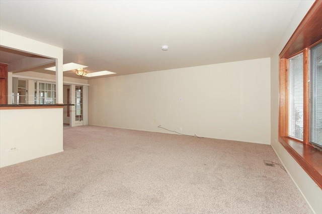 unfurnished living room featuring light colored carpet