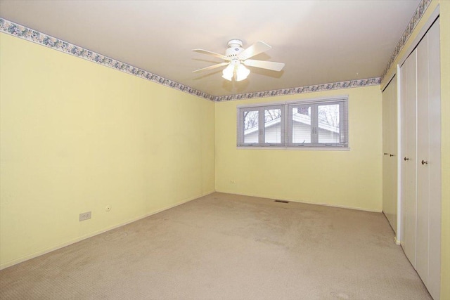 unfurnished bedroom with ceiling fan, a closet, and light carpet