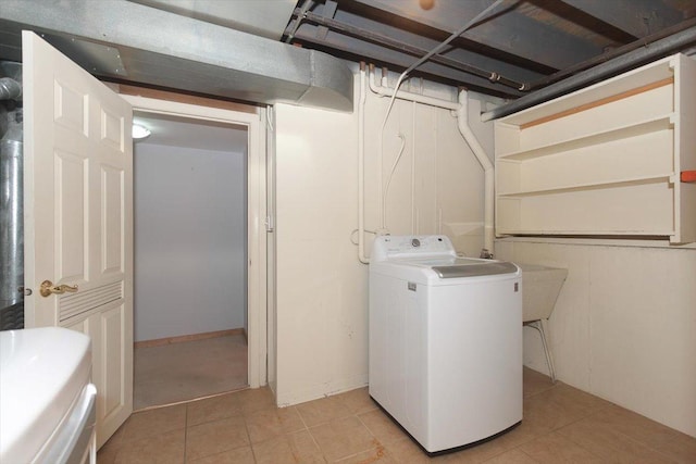 clothes washing area featuring light tile patterned flooring, washer / dryer, and sink