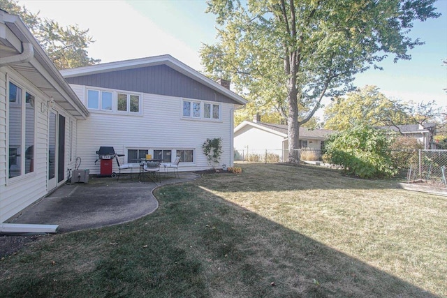 back of house with a yard and a patio