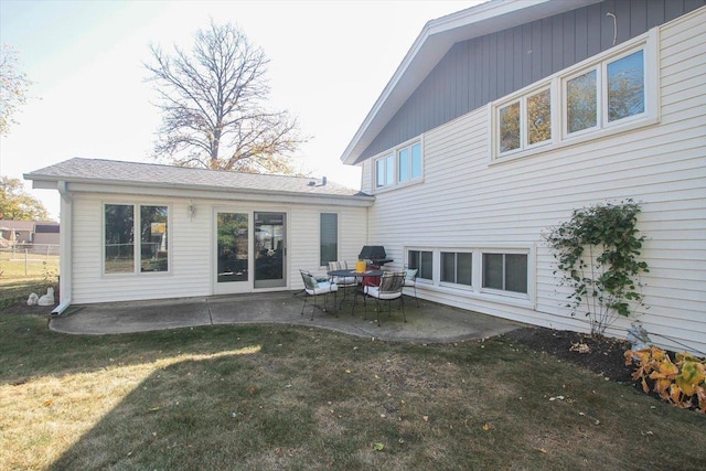 rear view of property featuring a patio area and a lawn