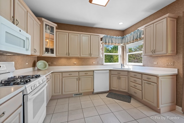 kitchen with sink, white appliances, light tile patterned floors, and backsplash