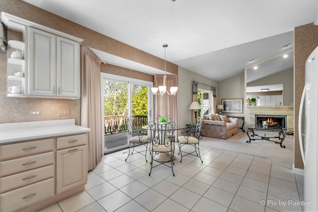 dining area featuring light tile patterned flooring, lofted ceiling, and a chandelier