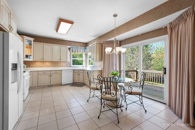 kitchen featuring white appliances, decorative backsplash, a chandelier, and light tile patterned flooring