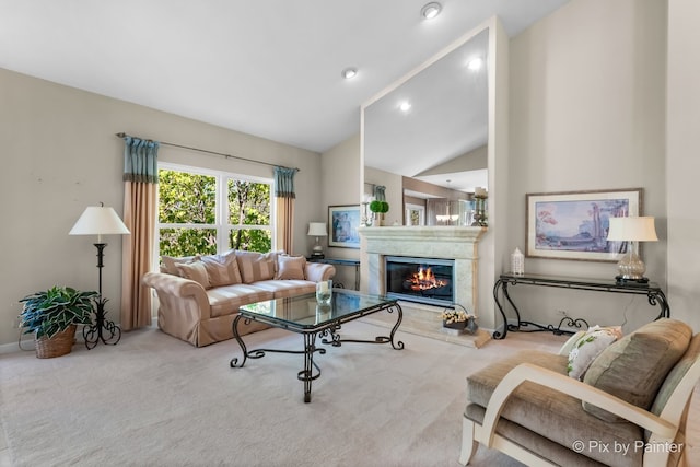 carpeted living room with a high end fireplace and high vaulted ceiling