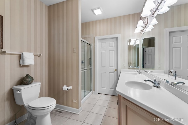 bathroom with tile patterned flooring, a notable chandelier, a shower with shower door, and toilet