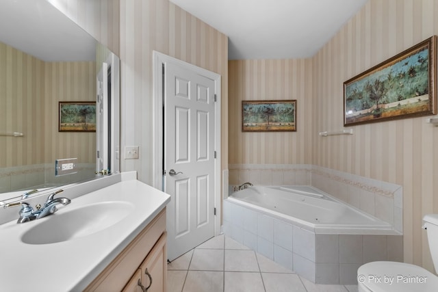 bathroom with a relaxing tiled tub, vanity, toilet, and tile patterned flooring