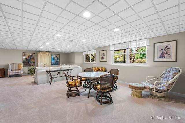 carpeted dining space featuring a paneled ceiling