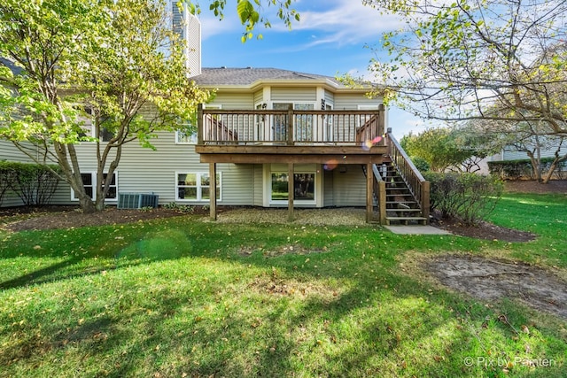 rear view of house featuring a wooden deck and a lawn