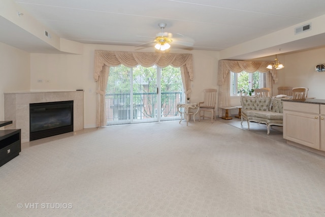 living room with ceiling fan with notable chandelier and light colored carpet