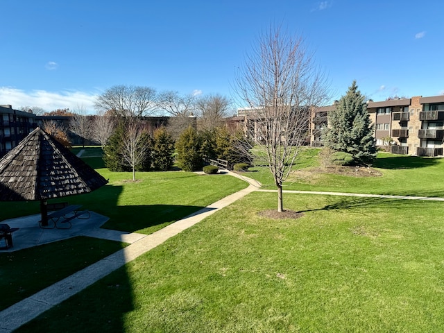 view of property's community with a lawn and a patio