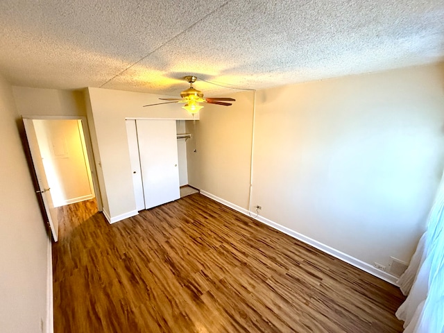 unfurnished bedroom with ceiling fan, dark hardwood / wood-style flooring, and a textured ceiling