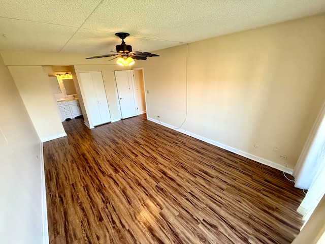 unfurnished bedroom with ceiling fan and dark wood-type flooring