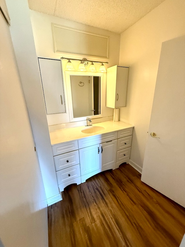 bathroom with vanity, a textured ceiling, and hardwood / wood-style flooring