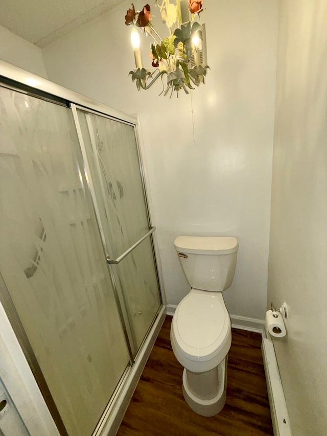 bathroom featuring toilet, a shower with shower door, a textured ceiling, and hardwood / wood-style flooring