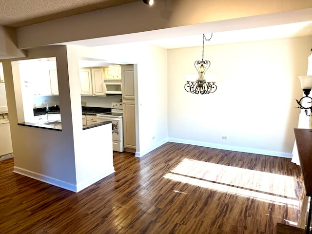 kitchen featuring white appliances, decorative light fixtures, a textured ceiling, a notable chandelier, and dark hardwood / wood-style flooring