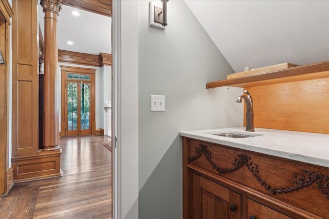 bathroom with hardwood / wood-style floors, lofted ceiling, and sink