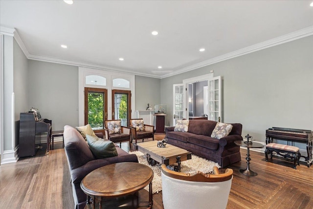 living room with wood-type flooring and ornamental molding