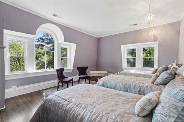 bedroom with dark hardwood / wood-style flooring, ornamental molding, and an inviting chandelier