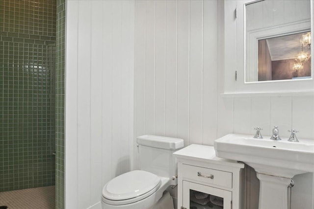 bathroom featuring wooden walls, toilet, and tiled shower