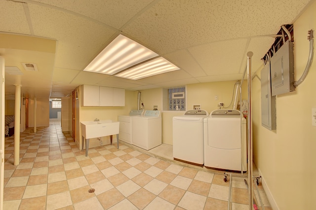 laundry room with electric panel, cabinets, and independent washer and dryer