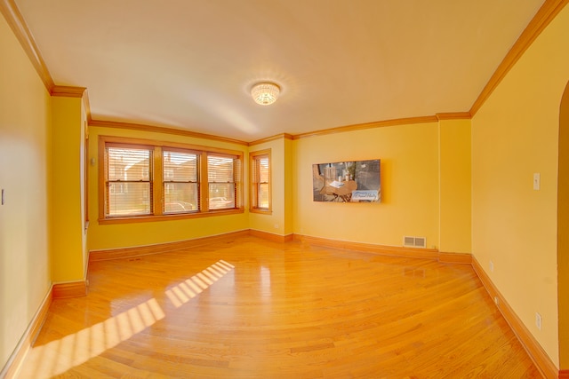 empty room with light hardwood / wood-style flooring and ornamental molding