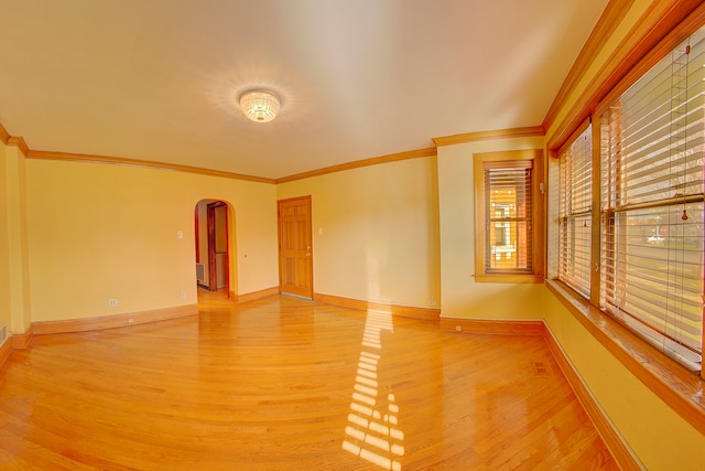 empty room featuring crown molding and hardwood / wood-style flooring