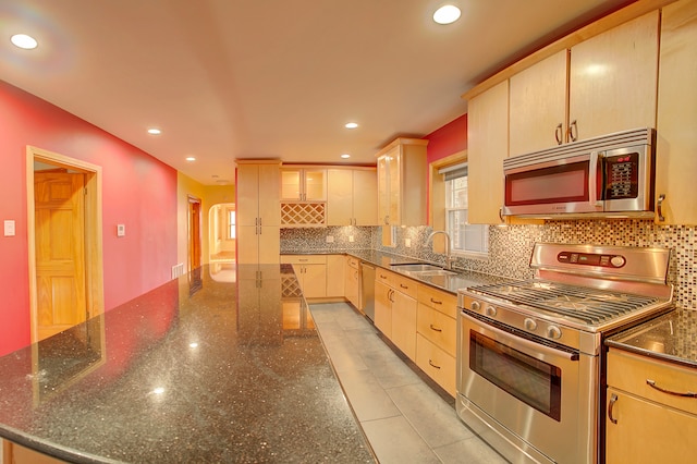 kitchen featuring light brown cabinets, stainless steel appliances, tasteful backsplash, and sink