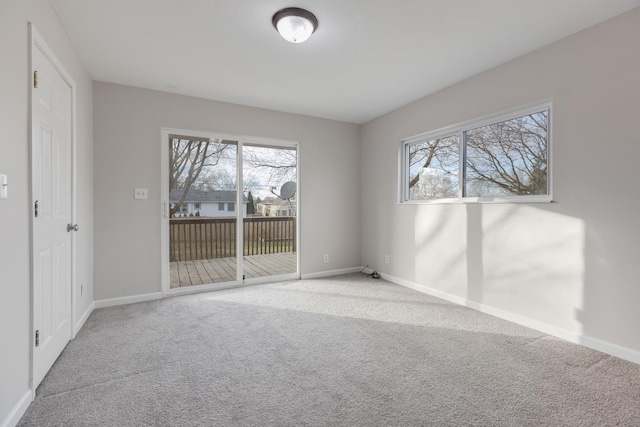 carpeted spare room featuring plenty of natural light