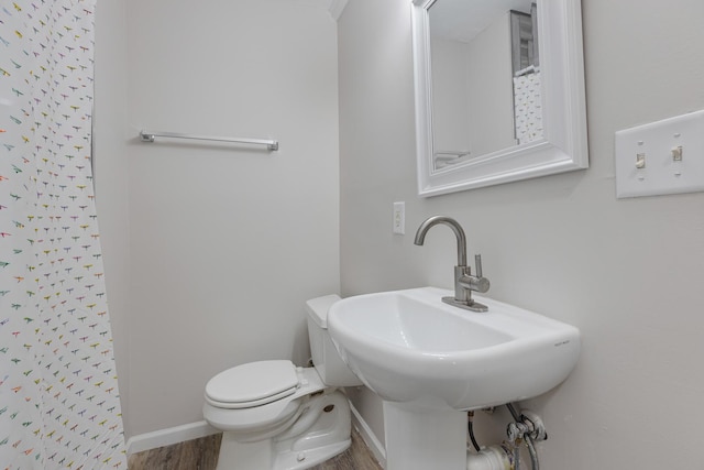 bathroom featuring hardwood / wood-style flooring, sink, toilet, and walk in shower