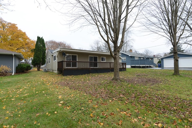 view of front of house featuring an outdoor structure, a garage, a wooden deck, and a front yard